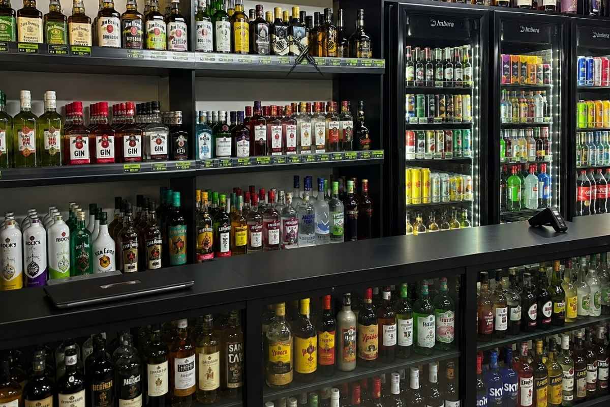 Geladeiras e prateleiras de destilados e cervejas da Adega Caldeira